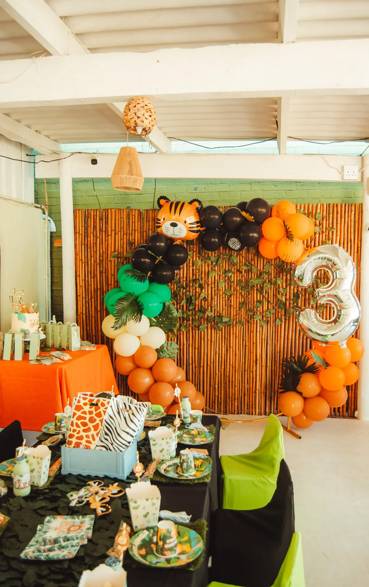 Tiger-themed kids party setup with orange and black balloon decor