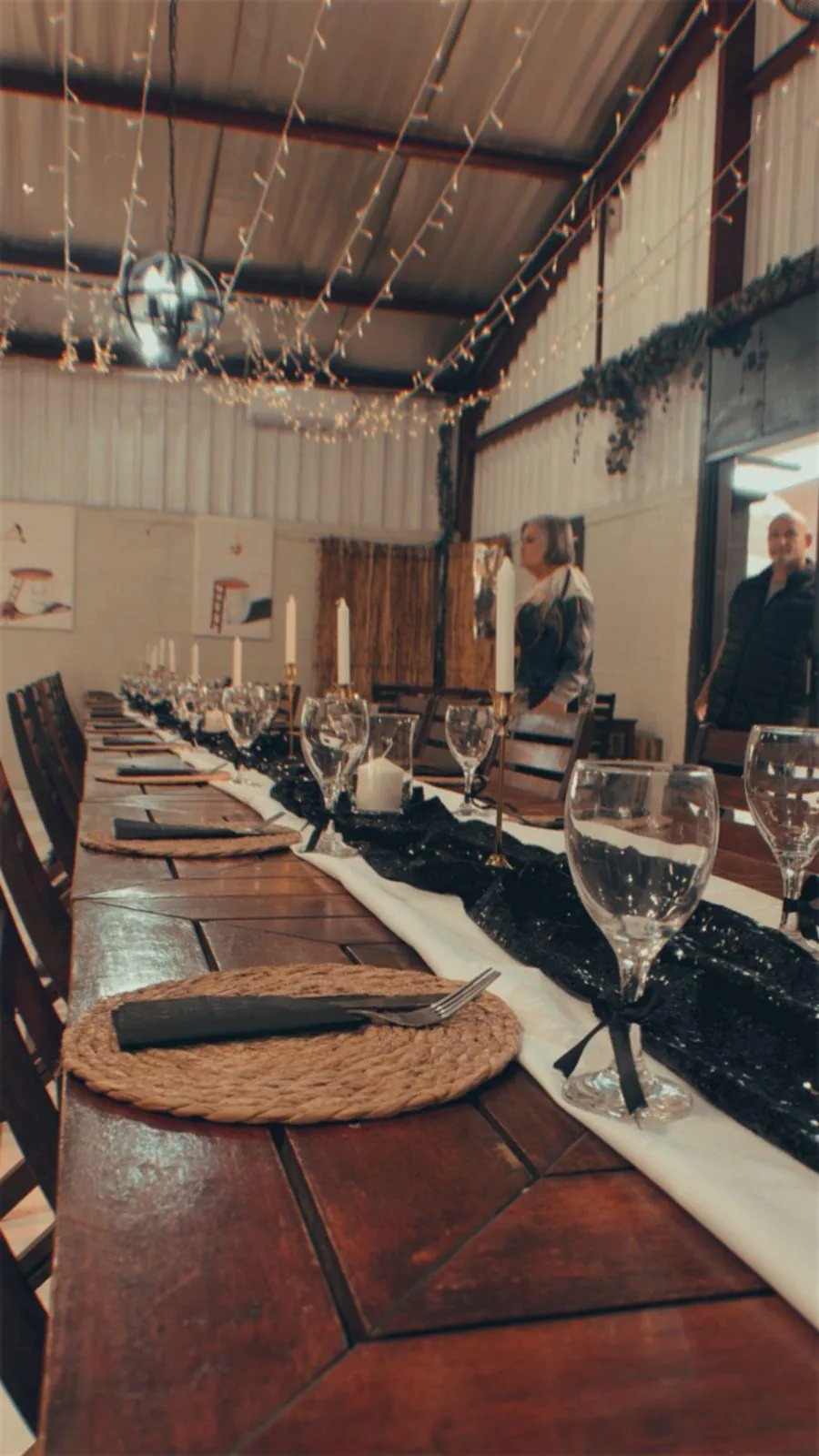 Evening reception table setting with black and white styling, candles and fairy lights