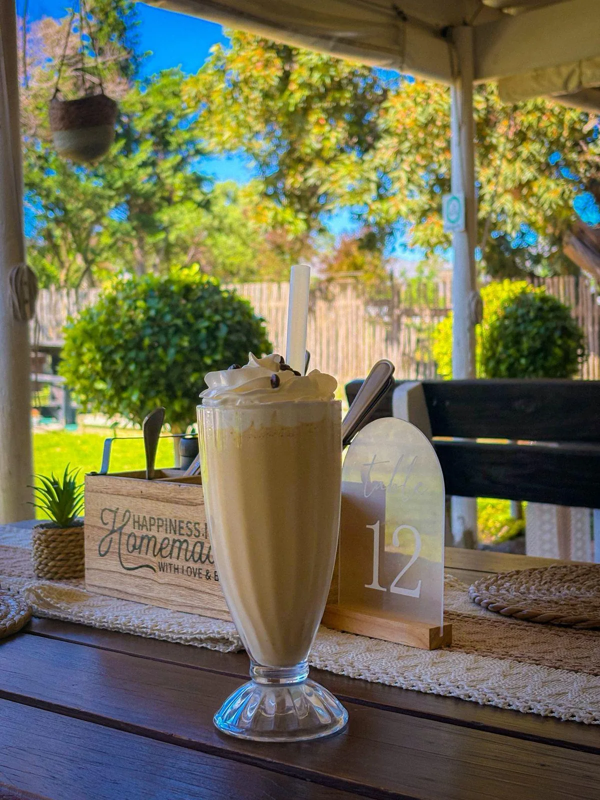 Creamy milkshake served at an Olive & Vine terrace table